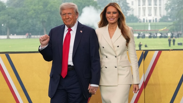 President Donald Trump and wife Melania Trump pose for photos at a military parade event