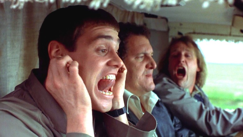 Jim Carrey's Lloyd with his fingers in his ears next to Mike Starr's Joe Mentalino and Jeff Daniels' Harry n 1994's "Dumb and Dumber"