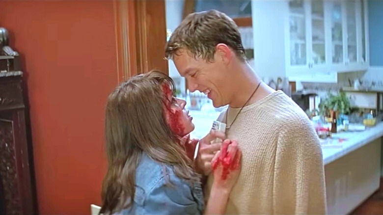 Neve Campbell's Sidney Prescott, covered in blood, leaning on Matthew Lillard's Stuart in 1996's "Scream"