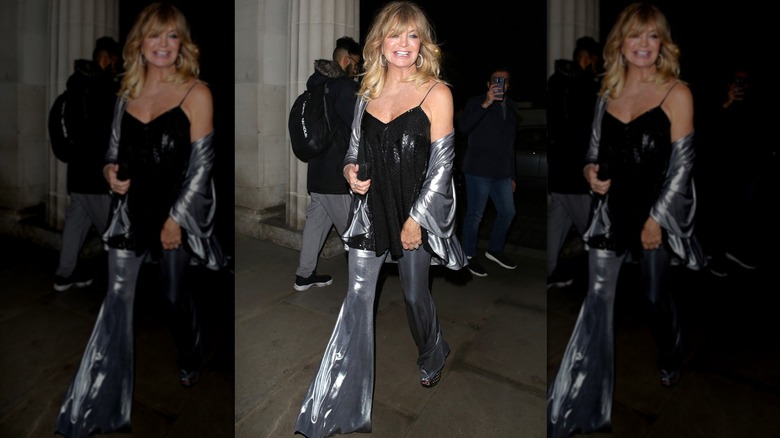Goldie Hawn in slinky silver bell-bottom pants and black sequin camisole