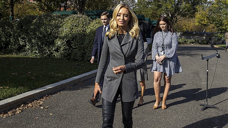 Kayleigh McEnany walking outside in a gray jacket and tight black leather pants (2020)