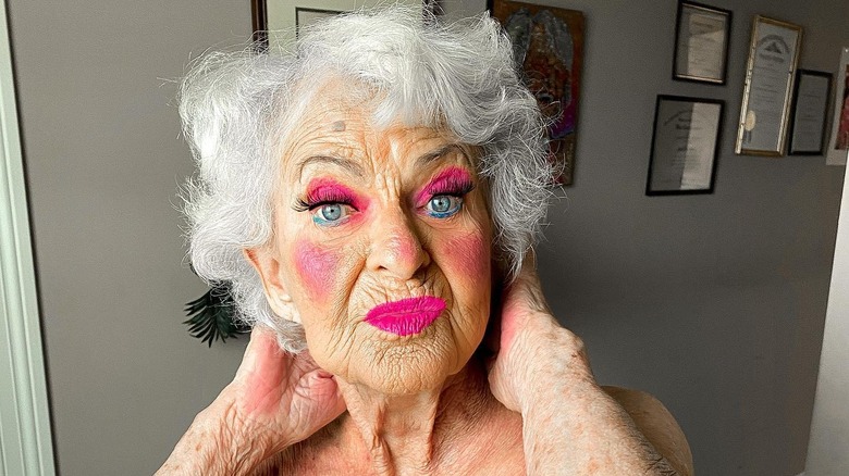 Baddie Winkle poses in a selfie wearing a corset and hot pink makeup