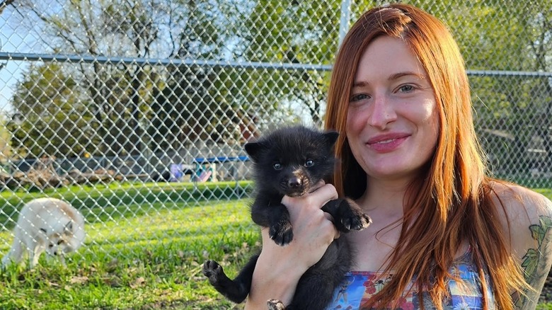 Mikayla Raines poses with two foxes
