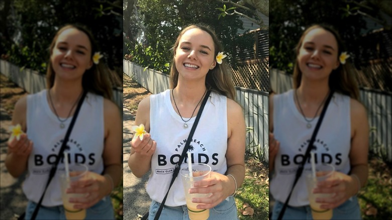 Stacey Hatfield posing with flowers outside