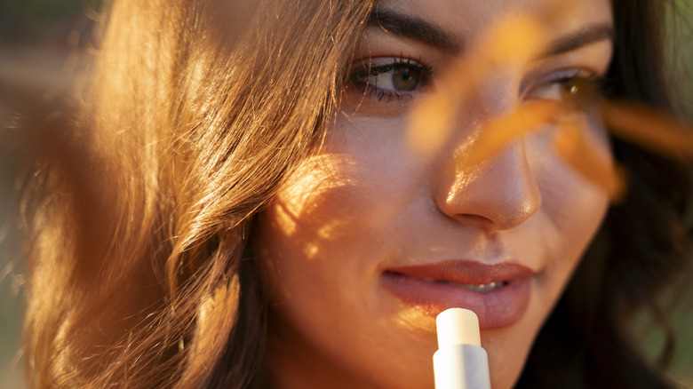 Woman applying lip balm