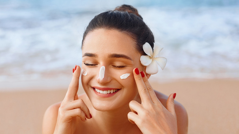 Woman applying sunscreen to her face