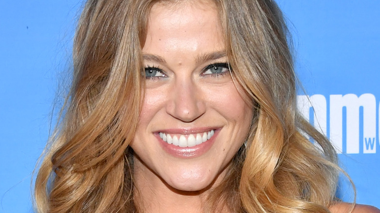 Adrianne Palicki smiles with wavy hair and blue eyeshadow