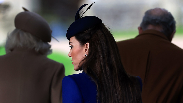 Queen Camilla, Princess Catherine, & King Charles walking with back to camera