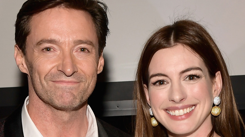 Anne Hathaway and Hugh Jackman smile for the camera at an event