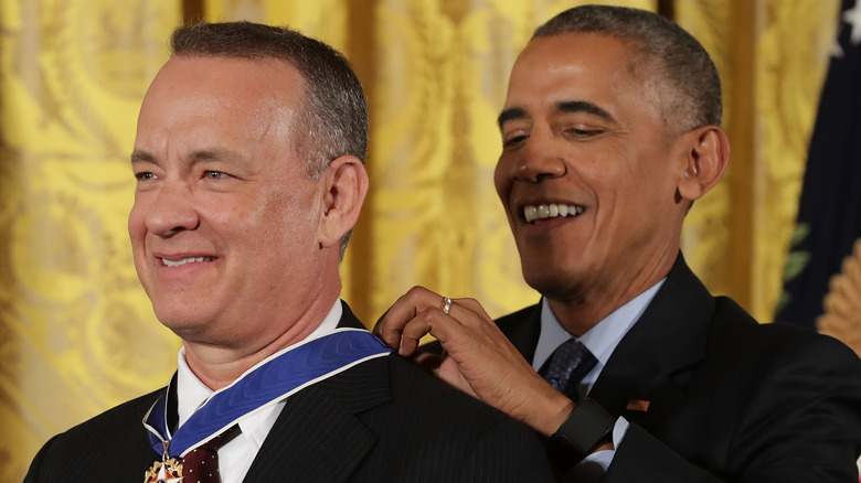 Tom Hanks and Barack Obama smiling as Obama awards Hanks the Presidential Medal of Freedom