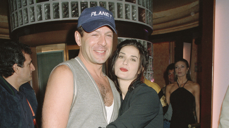 Younger Bruce Willis and Demi Moore posing