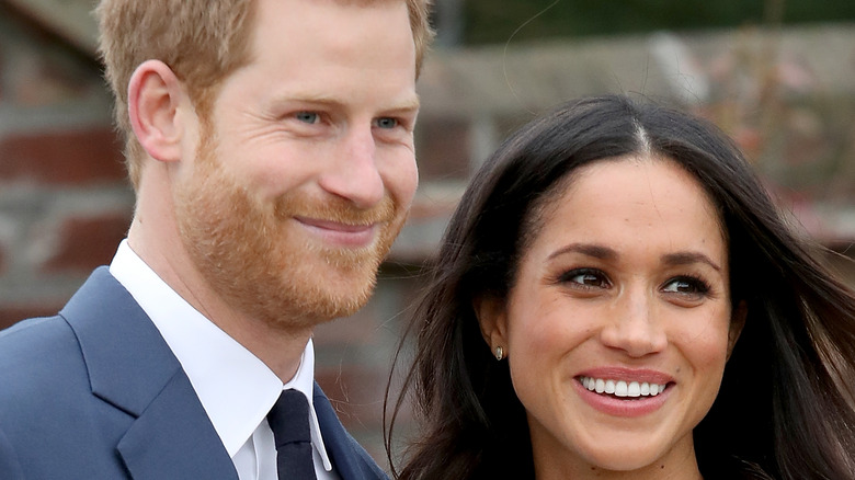 Prince Harry and Meghan Markle smiling at an event