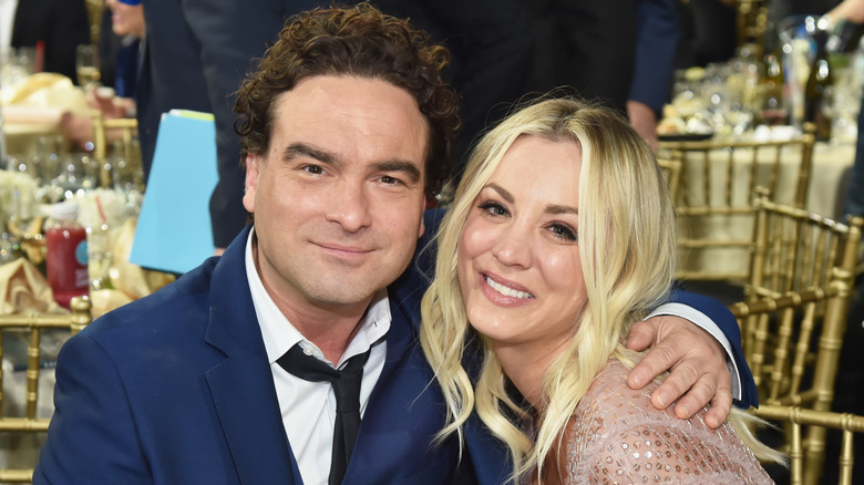 Johnny Galecki seated with his arm around Kaley Cuoco.