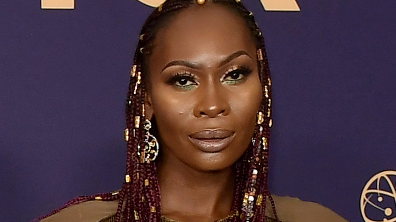 Dominique Jackson wears braid with gold earrings.