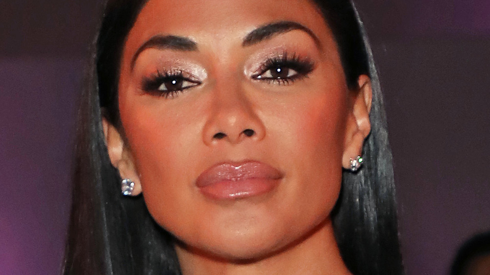 Nicole Scherzinger wears diamond earrings and glossy lipstick.