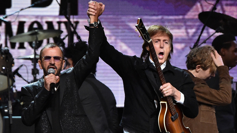 Ringo Starr and Paul McCartney perform on stage.