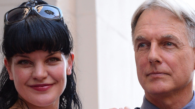 Pauley Perrette puts her arm on Mark Harmon and smiles.