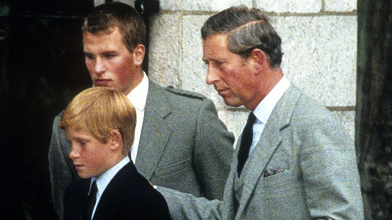 Peter Phillips, Prince Harry, and King Charles III looking at flowers left for Princess Diana