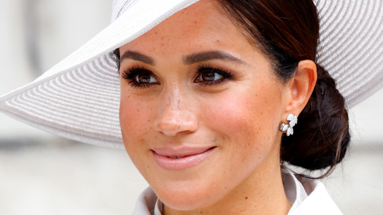 Meghan Markle smiling in a big hat