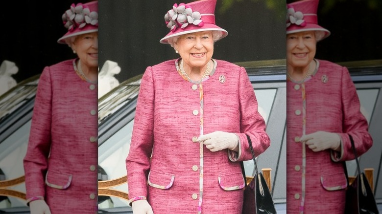 Queen Elizabeth II smiling in pink outfit