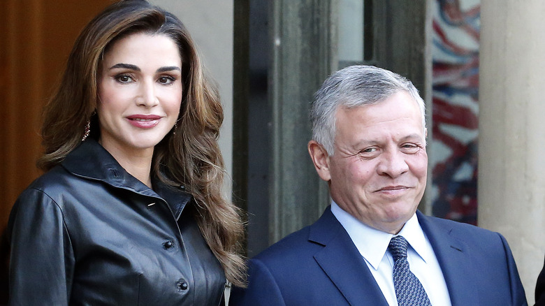 Queen Rania smiles next to husband King Abdullah II 