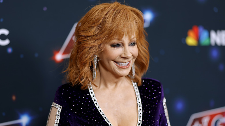 Reba McEntire smiling on an NBC red carpet