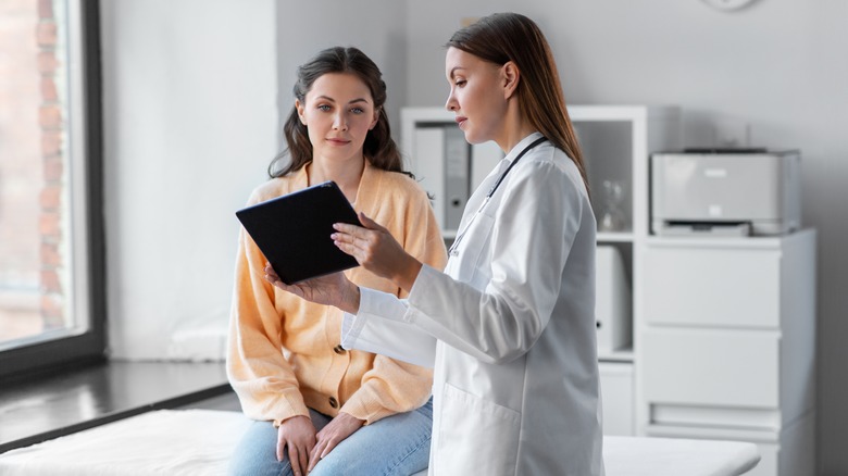 a woman with a doctor looking at a mammogram