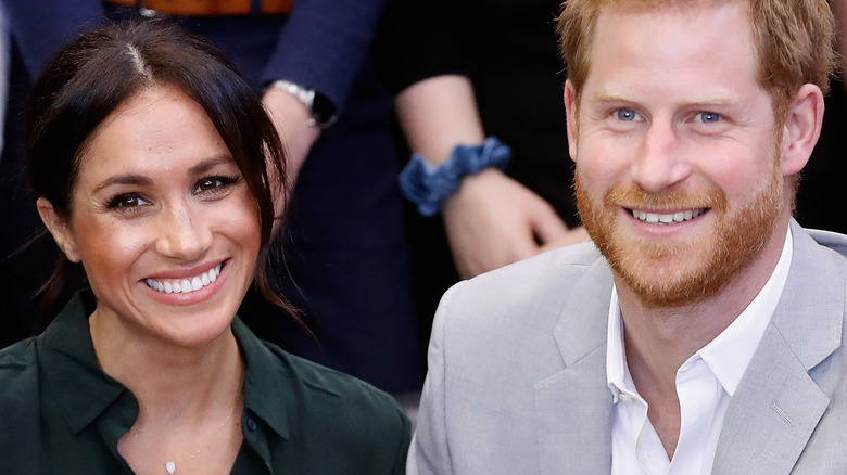 Meghan Markle and Prince Harry smile at an event.