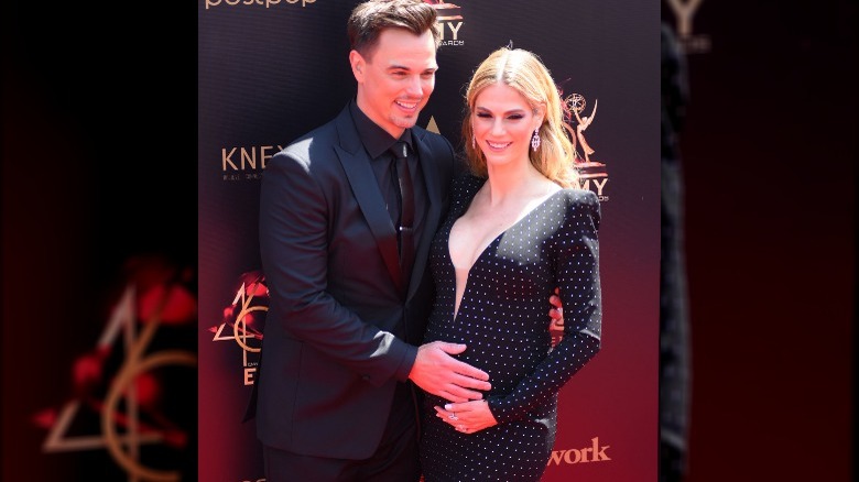 Darin Brooks cradling Kelly Kruger's stomach at an event