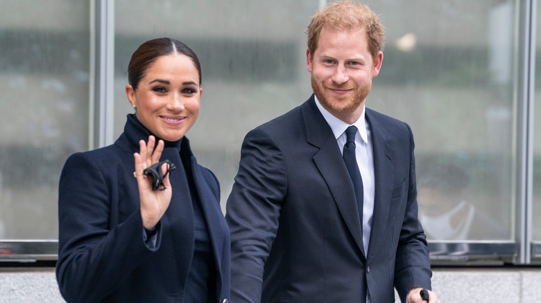 Prince Harry and Meghan Markle dark suits waving