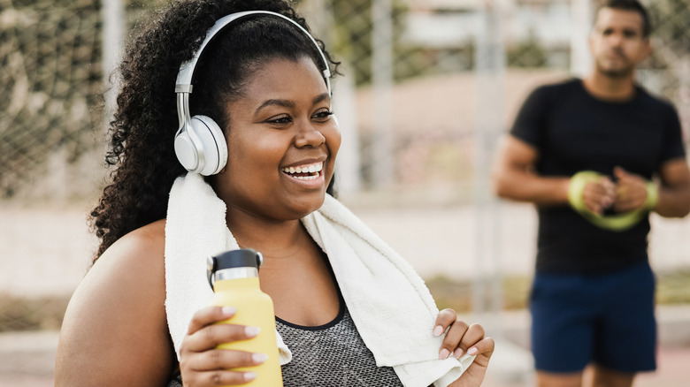Smiling woman with headphones exercising
