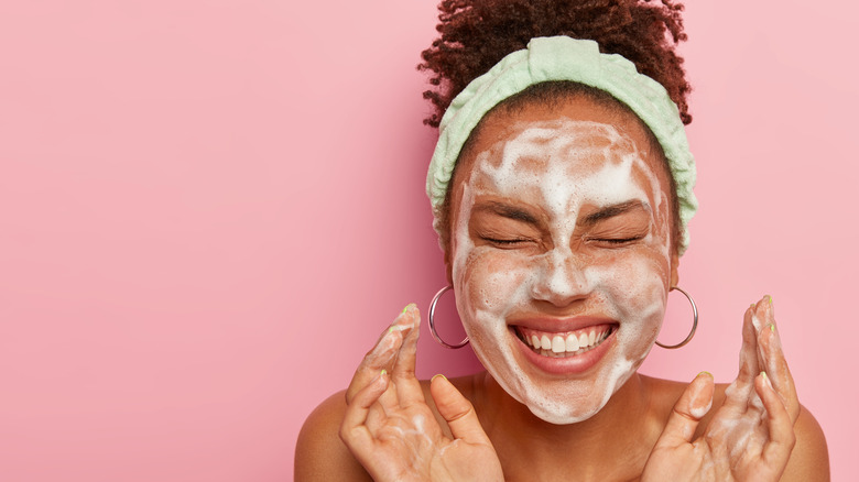 Woman smiles as she washes face