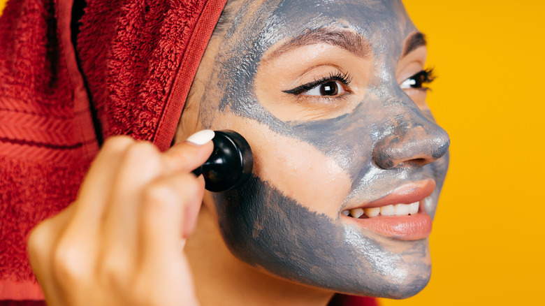 Woman removing charcoal face wash from her face