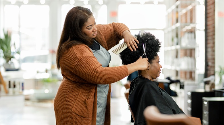 hair stylist trimming client's hair