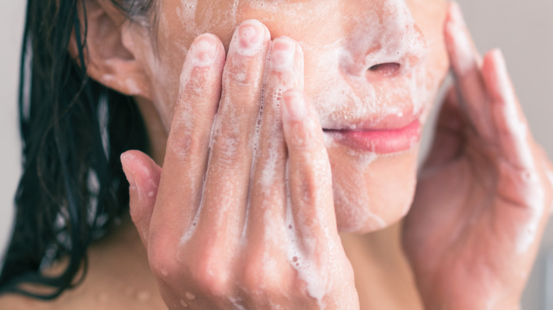 A woman exfoliating her face