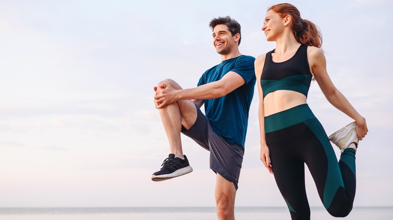 Man and woman stretching outside