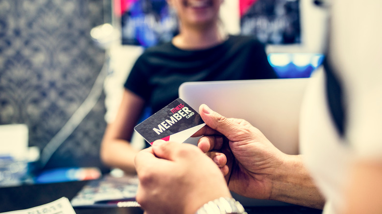 Hands holding a gym membership card