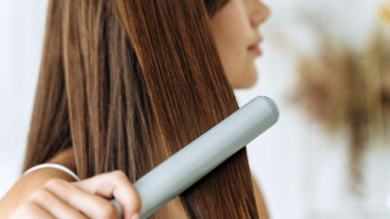 woman straightening her hair