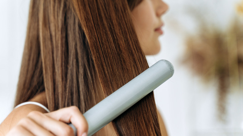 woman straightening her hair
