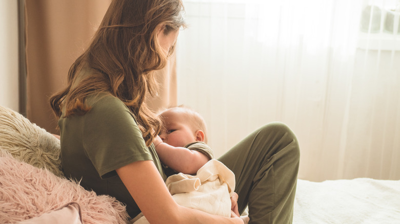 Mother breastfeeding baby in bed