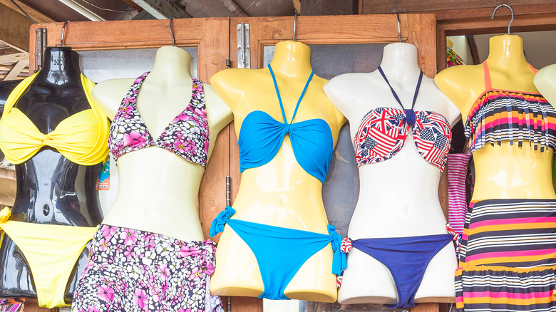 Mannequins wearing colorful bikinis at a store