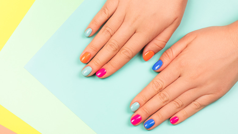 Neon painted nails on colorful background