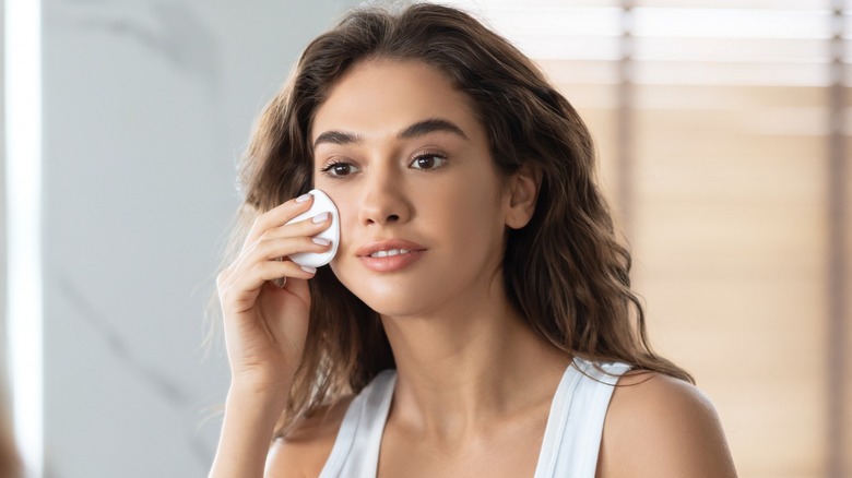 Woman using iodine for acne breakout