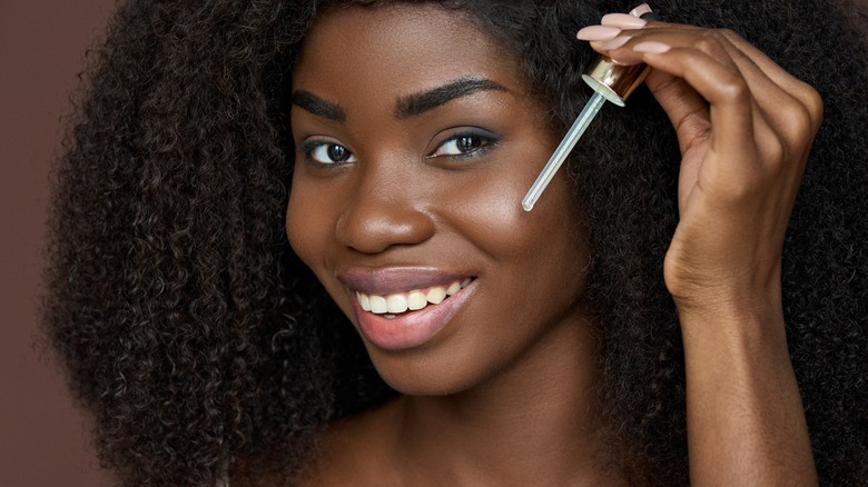 woman applying skincare to face