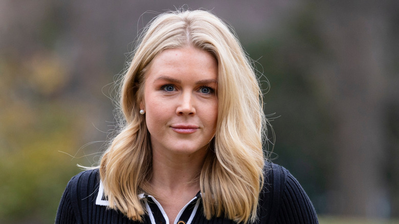 Karoline Leavitt smirking while wearing pearl earrings