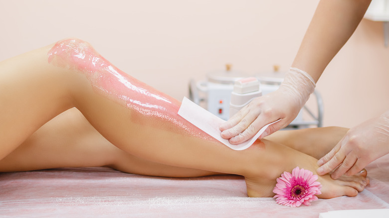 Woman having her legs waxed