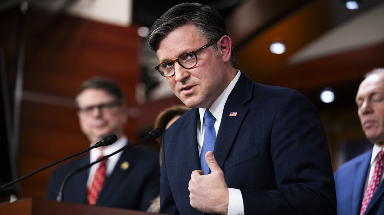 Mike Johnson speaks during a press conference in a blue suit