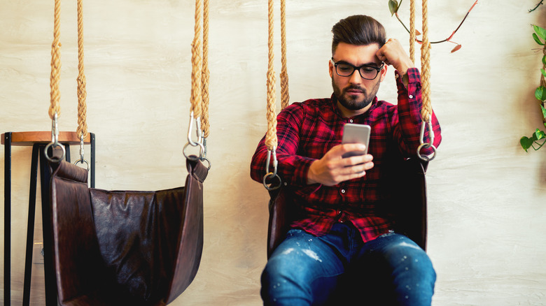 Anxious man looking at phone