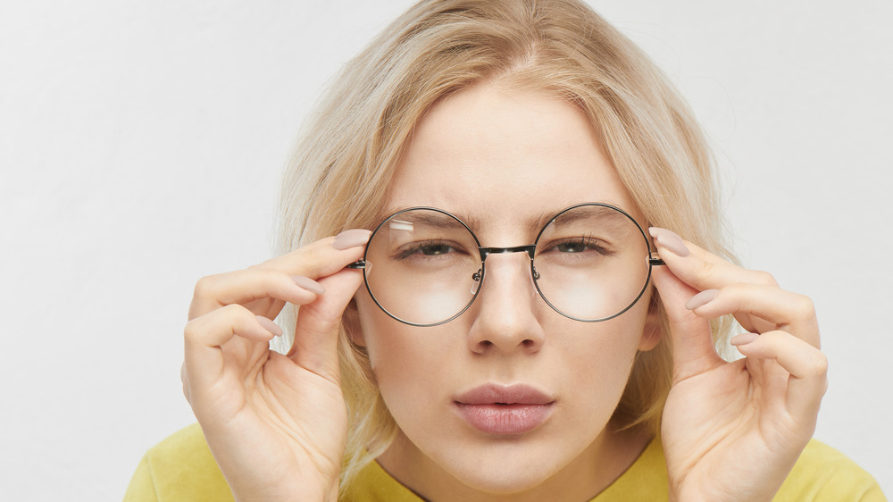 A woman squinting in glasses 