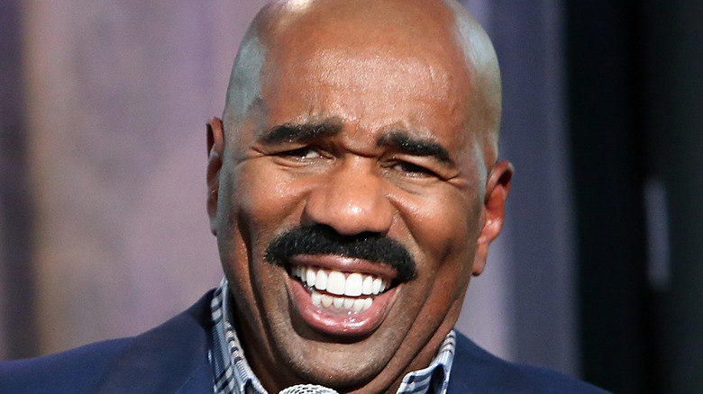Steve Harvey laughing with a microphone